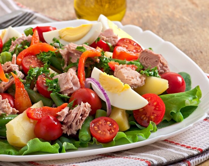 Delicious and colorful Cobb Salad with fresh greens, grilled chicken, crispy bacon, and ripe avocado