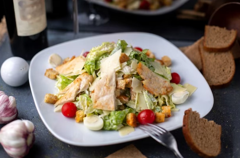 A vibrant and colorful Chicken Waldorf Salad with crisp apples, juicy grapes, and toasted walnuts on a white plate.