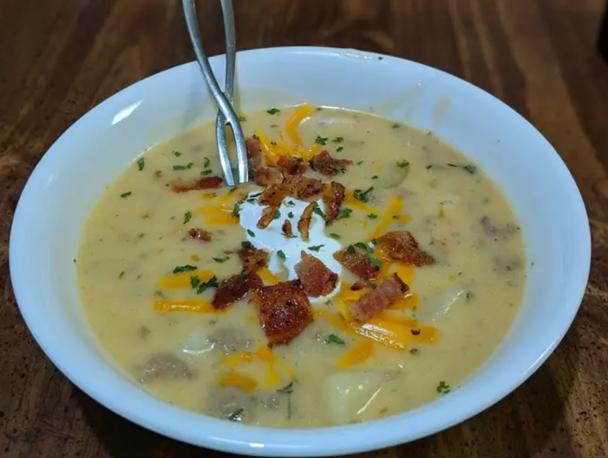 A bowl of homemade Cheeseburger Soup garnished with cheese and herbs, symbolizing warmth and comfort.