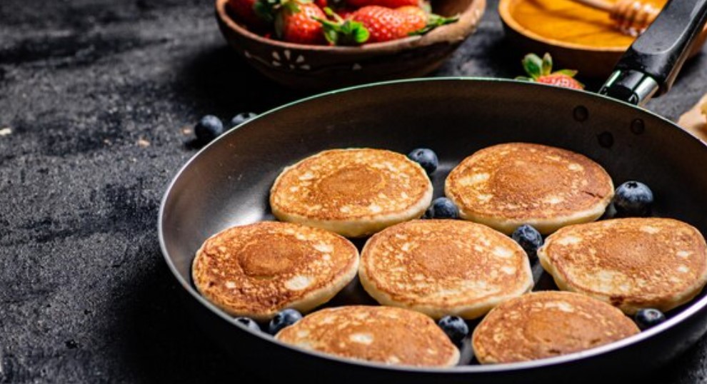 Stack of Premier Protein Pancakes topped with fresh berries and a drizzle of syrup