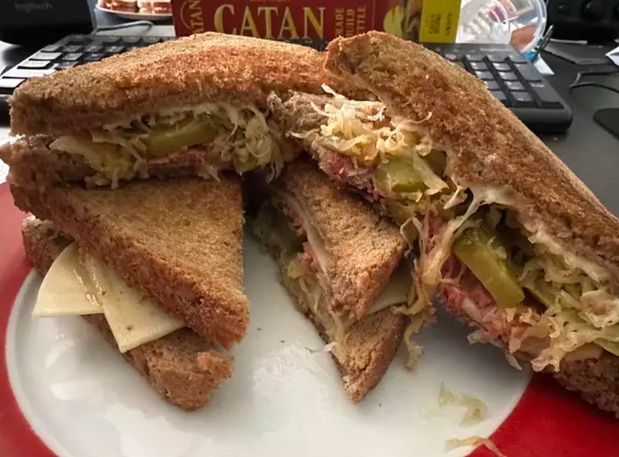 Delicious Reuben Sandwich with Corned Beef, Swiss Cheese, Sauerkraut, and Russian Dressing on Grilled Rye Bread