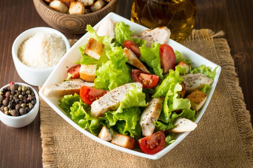 A bowl of Chicken Caesar Salad with crisp romaine, grilled chicken, and creamy dressing, Chicken Caesar Salad,