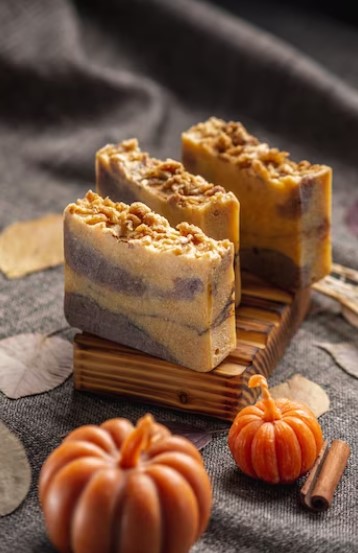 Freshly baked Pumpkin Cheesecake Brownies on a rustic wooden table with autumn decoration