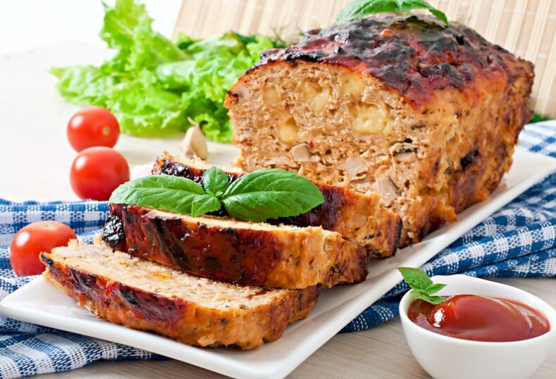 Sliced homemade easy pleasing meatloaf on a serving platter, showcasing its juicy interior and perfectly browned crust.